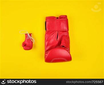 two red boxing gloves on a yellow background, concept of difference