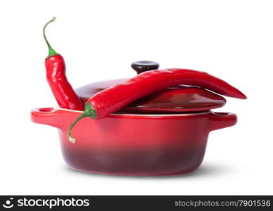 Two red chili peppers in saucepan with lid isolated on white background