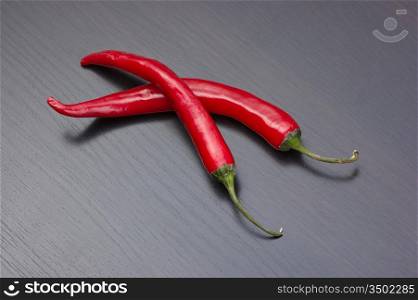 Two red chili peppers on the kitchen table