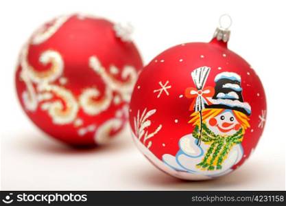 Two red christmas balls with drawing of snowman and snow isolated on white background