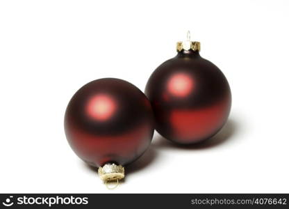 Two red christmas tree ornaments over white