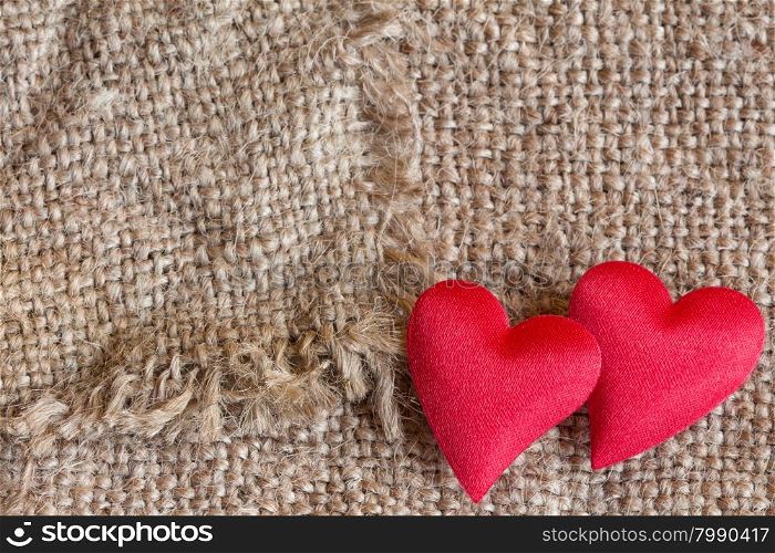 Two red decorative hearts on canvas background