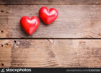 Two red hearts on old shabby wooden background with copy space