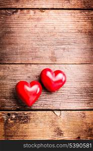 Two red hearts on old shabby wooden background with copy space