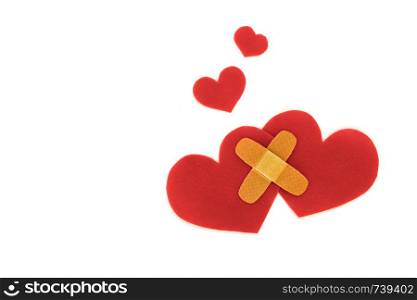 Two red hearts symbol conected with medical patch on white background, love concept. forgiveness. Two red hearts symbol with medical patch on white background, love concept. forgiveness