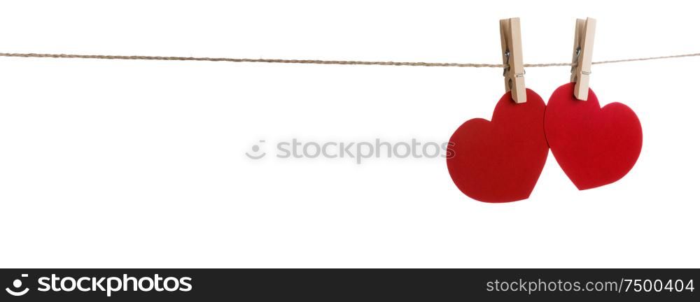 Two red paper hearts pinned together isolated on white background. Two red hearts pinned on white