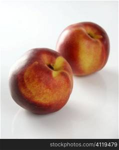 Two red peaches in white background