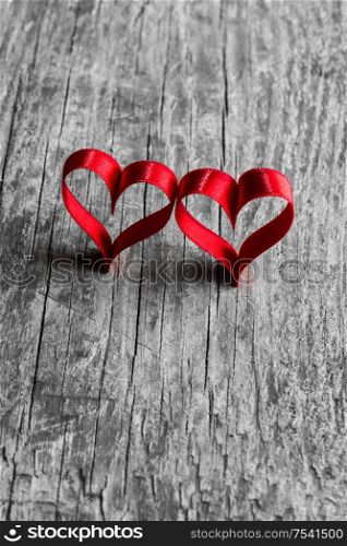 Two red ribbon hearts on wooden background with copy space for text, Valentines day concept. Red ribbon hearts on wood