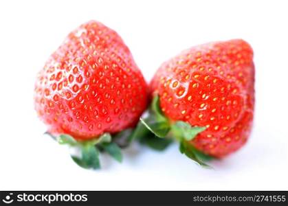 Two red strawberry fruits on a white background