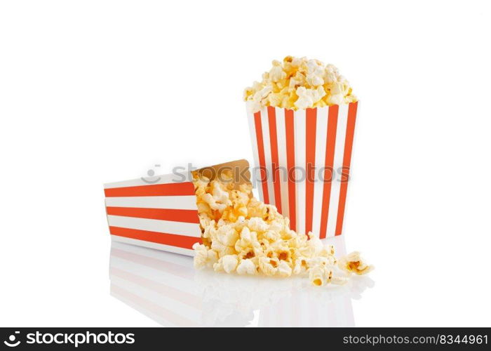 Two red white striped carton buckets with tasty cheese popcorn, isolated on white background. Box with scattering of popcorn grains. Movies, cinema and entertainment concept.