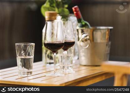two red wine glasses glass water wooden table
