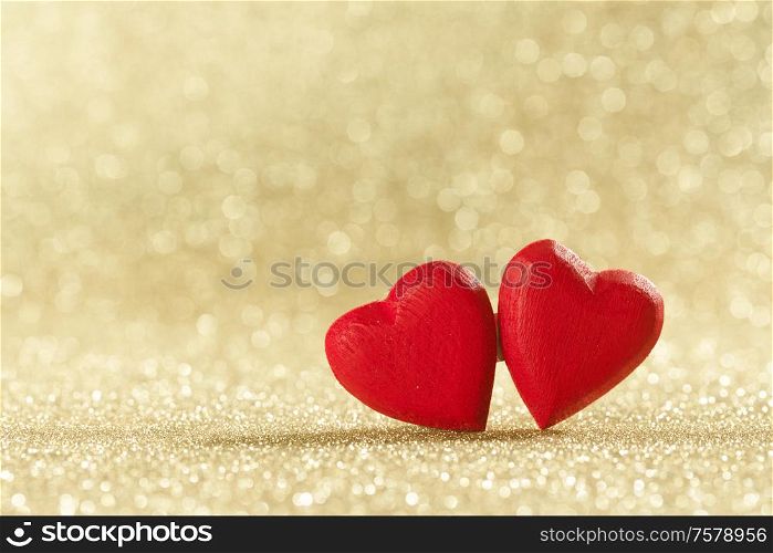 Two red wooden hearts symbol of love on background with beautiful bokeh, Saint Valentine Day celebration, copy space for text. Red hearts symbol of love