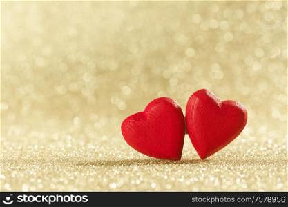 Two red wooden hearts symbol of love on background with beautiful bokeh, Saint Valentine Day celebration, copy space for text. Red hearts symbol of love