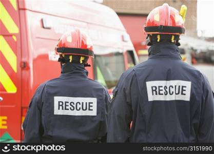 Two rescue workers standing near rescue vehicle