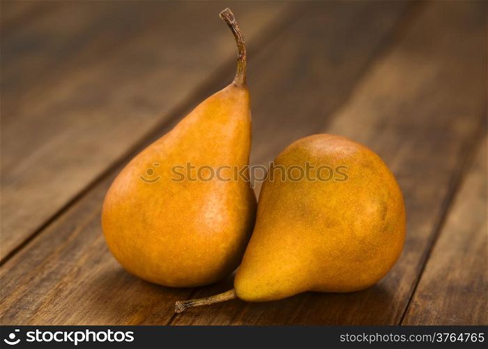 Two ripe Bosc pears on dark wood (Selective Focus, Focus on the front of the pears)