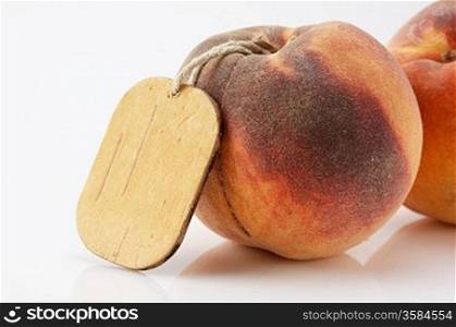 two ripe peach with tag on white background