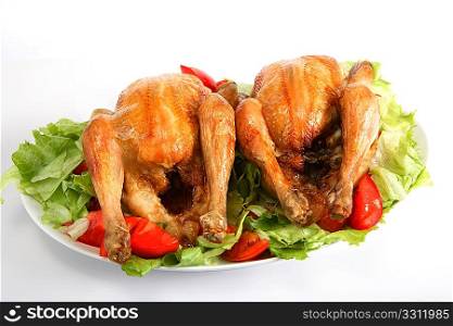 Two roast chickens on a bed of salad