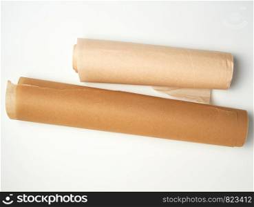 two rolls of brown parchment paper for baking on a white background, top view