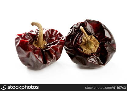 Two round Mediterranean dried dark red peppers