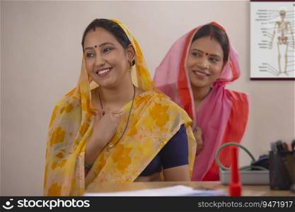 Two rural women sitting together in a clinic
