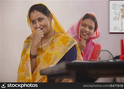 Two rural women sitting together in a clinic