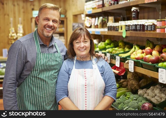 Two Sales Assistant At Vegetable Counter Of Farm Shop
