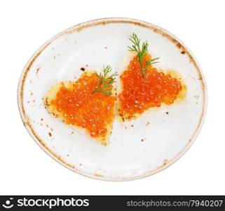 Two sandwiches heart shaped with red caviar on a porcelain plate