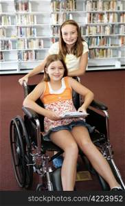 Two school girls at the library. One is in a wheelchair.