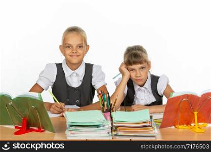 Two schoolgirls at a desk, one funny, the other upset