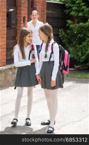 Two schoolgirls talking while going to school from home