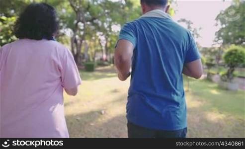two senior couple inside public park, healthy retirement life, running exercise, healthy body care, view from behind, outdoor activities on sunny day, family member get together exercise for health