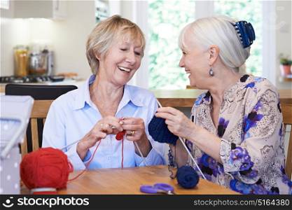 Two Senior Female Friends Knitting At Home Together