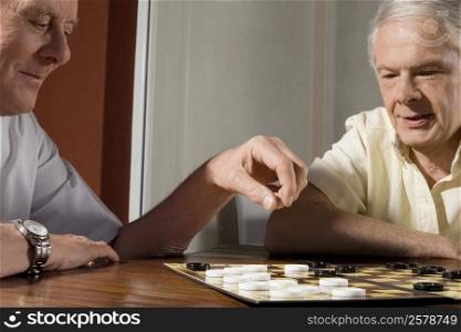 Two senior men playing checkers