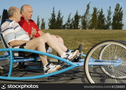Two senior men riding a quadracycle
