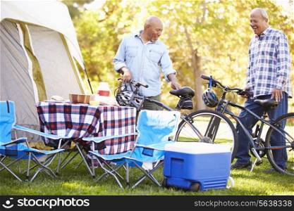 Two Senior Men Riding Bikes On Camping Holiday