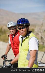 Two Senior men with bikes on road