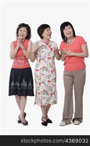 Two senior women and a mature woman laughing