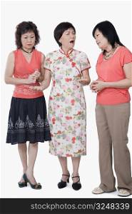 Two senior women and a mature woman standing together and talking