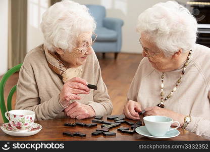 Two Senior Women Playing Dominoes At Day Care Centre