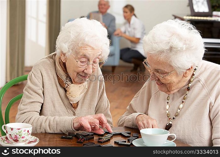 Two Senior Women Playing Dominoes At Day Care Centre