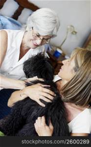 Two senior women smiling with a dog