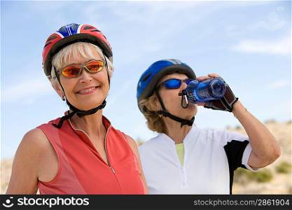 Two Senior women wearing cycling helmets