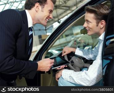 two serious businessmen with laptop in the car