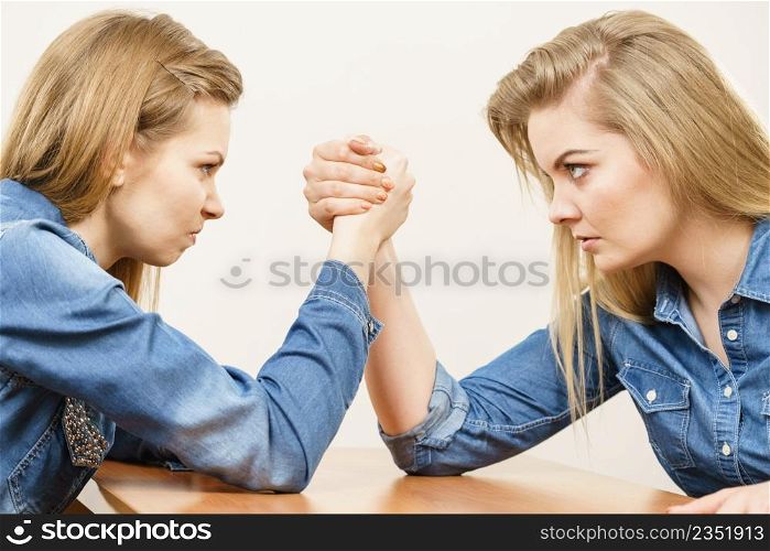 Two serious competetive women having arm wrestling fight, compete with each other.. Two women having arm wrestling fight
