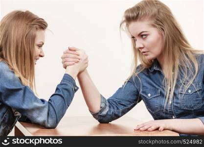 Two serious competetive women having arm wrestling fight, compete with each other.. Two women having arm wrestling fight