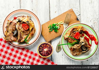 Two servings of roast beef,decorated with vegetables on decorated table.Top view