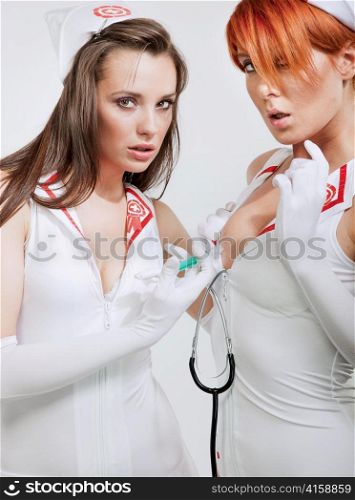 Two sexy nurses making a breast injection