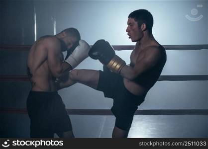 Two shirtless muscular man fighting Kick boxing combat in boxing ring. High quality photo. Two shirtless muscular man fighting Kick boxing combat in boxing ring.