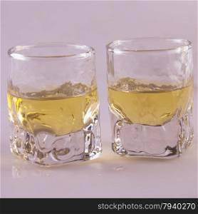 Two shots of whisky over gray background, square image