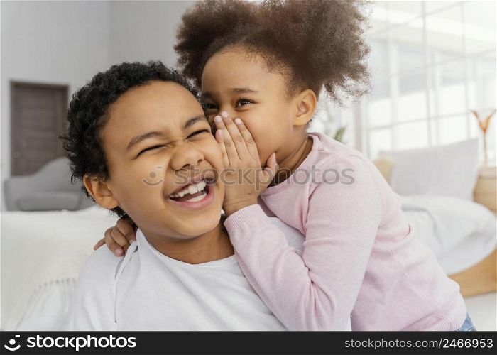 two siblings telling each other secrets home